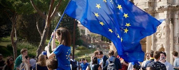 Tjej håller i en stor EU-flagga